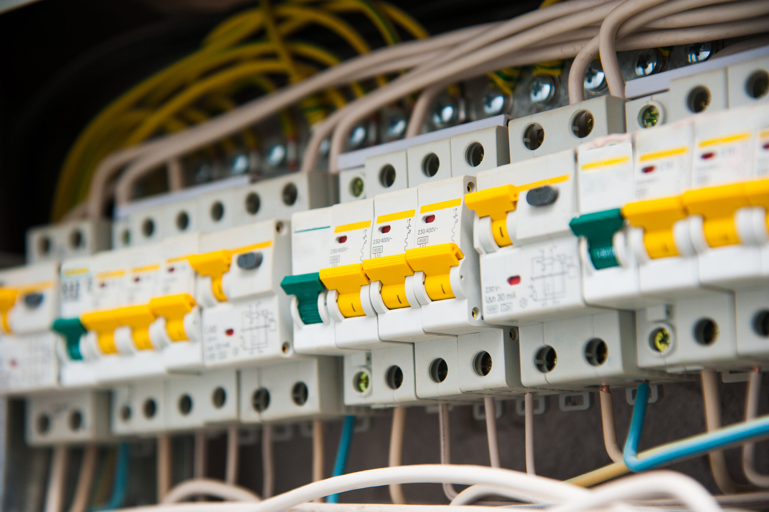 Nahaufnahme eines elektrischen Verteilerschranks mit Sicherungsautomaten, Verdrahtung und modernen Schutzeinrichtungen.