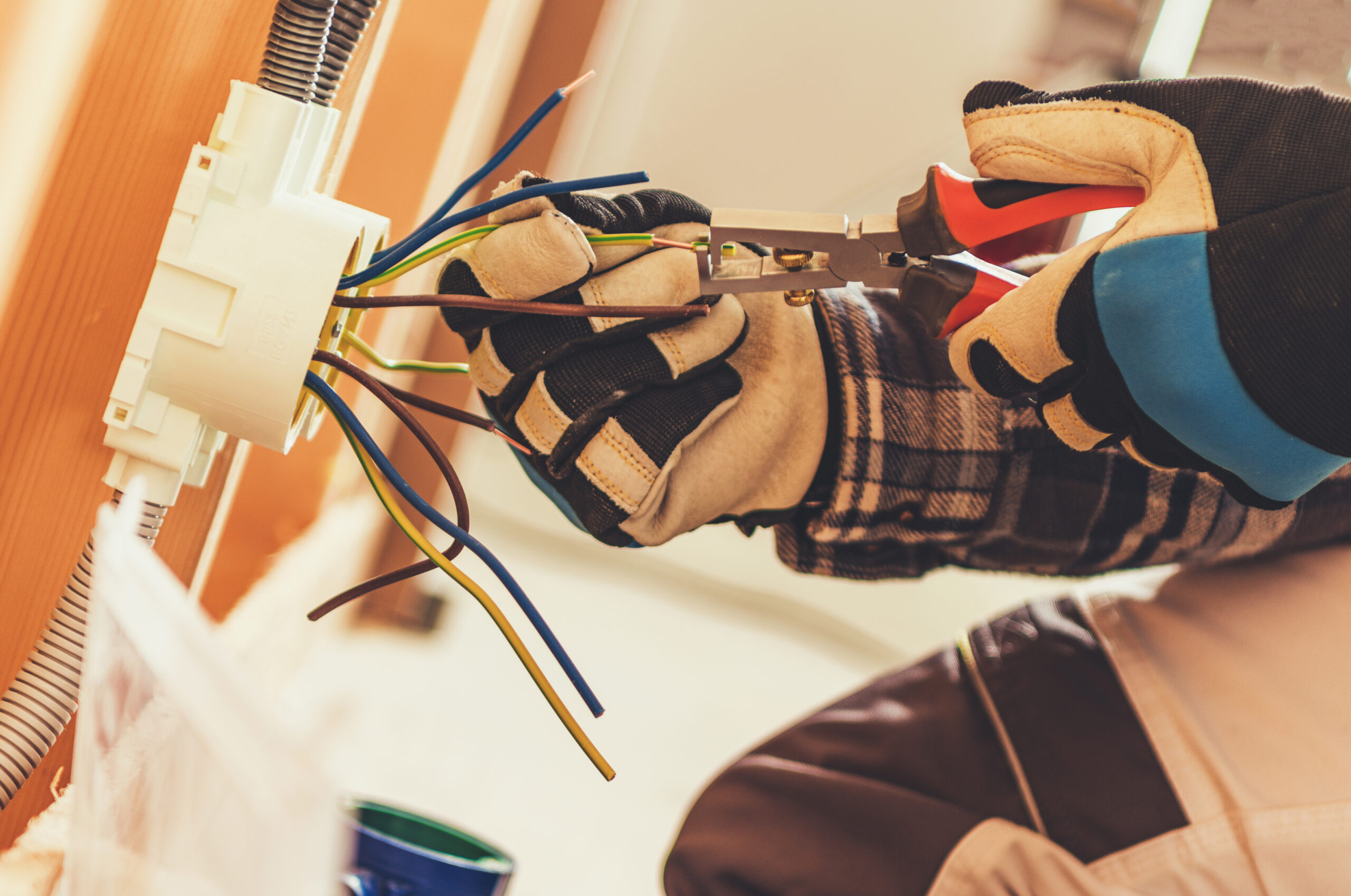 Fachgerechte Elektroinstallation im Innenbereich Elektriker verbindet und bearbeitet Leitungen in einer Unterputzdose bei der Installation einer elektrischen Anlage.