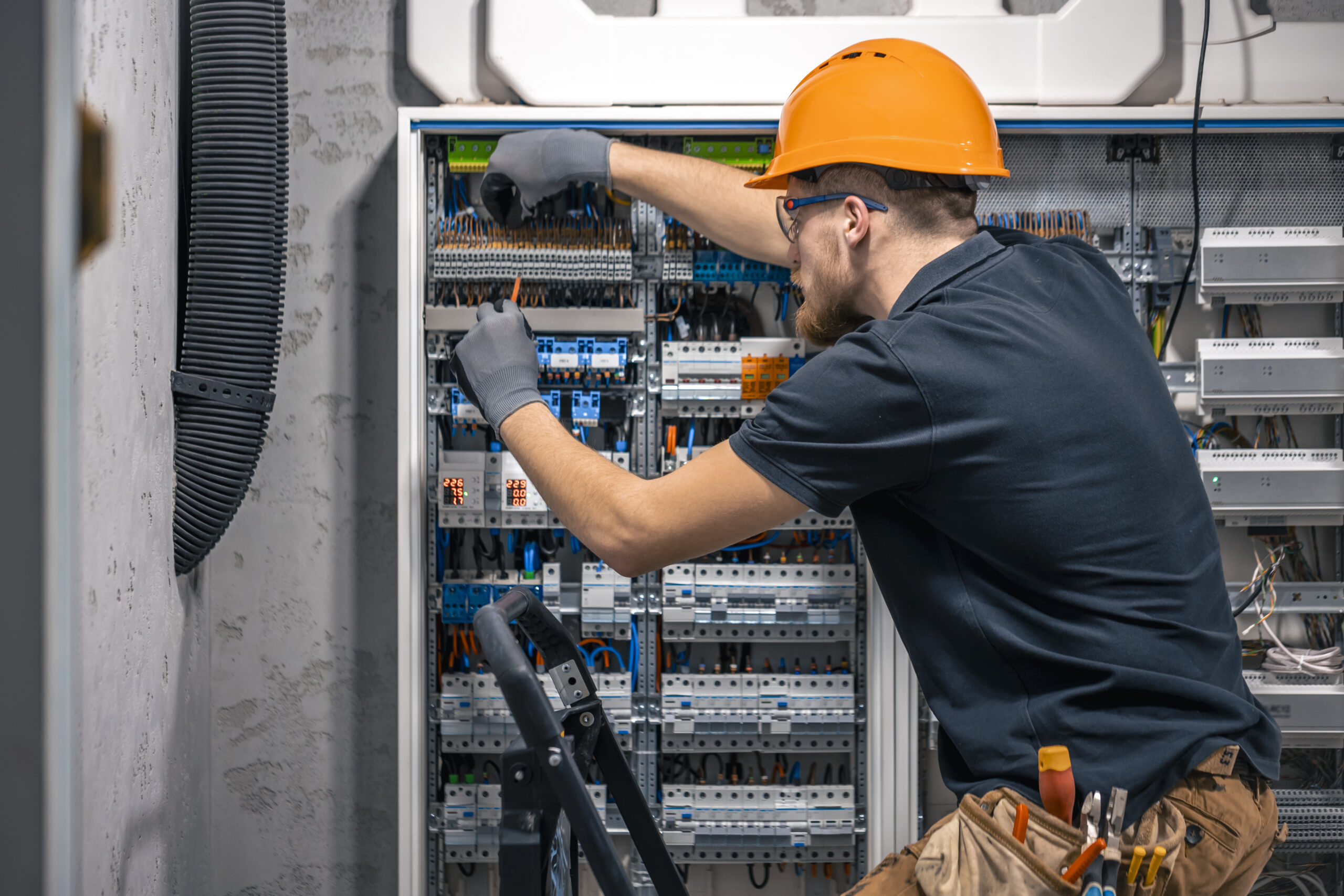 Fachgerechte Ausführung mit höchster Sorgfalt Elektriker arbeitet an einem geöffneten Schaltschrank und überprüft die fachgerechte Verdrahtung einer elektrischen Anlage.